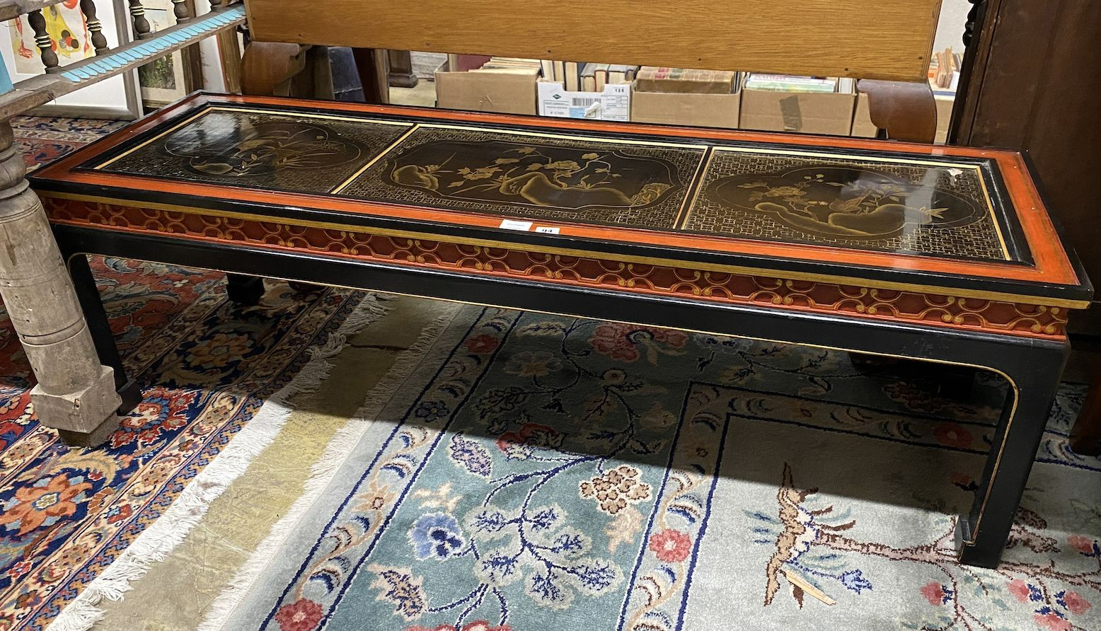 A Chinese black and red lacquered coffee table, the top inset three 18th century lacquer panels, length 138cm, depth 47cm, height 45cm